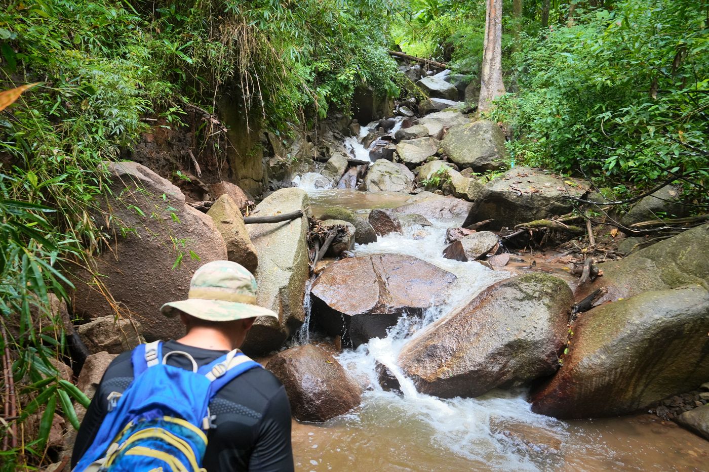 Climbing beside a cascade over big boulders