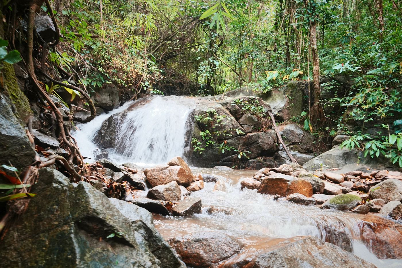 A waterfall pouring over rocks in the forest