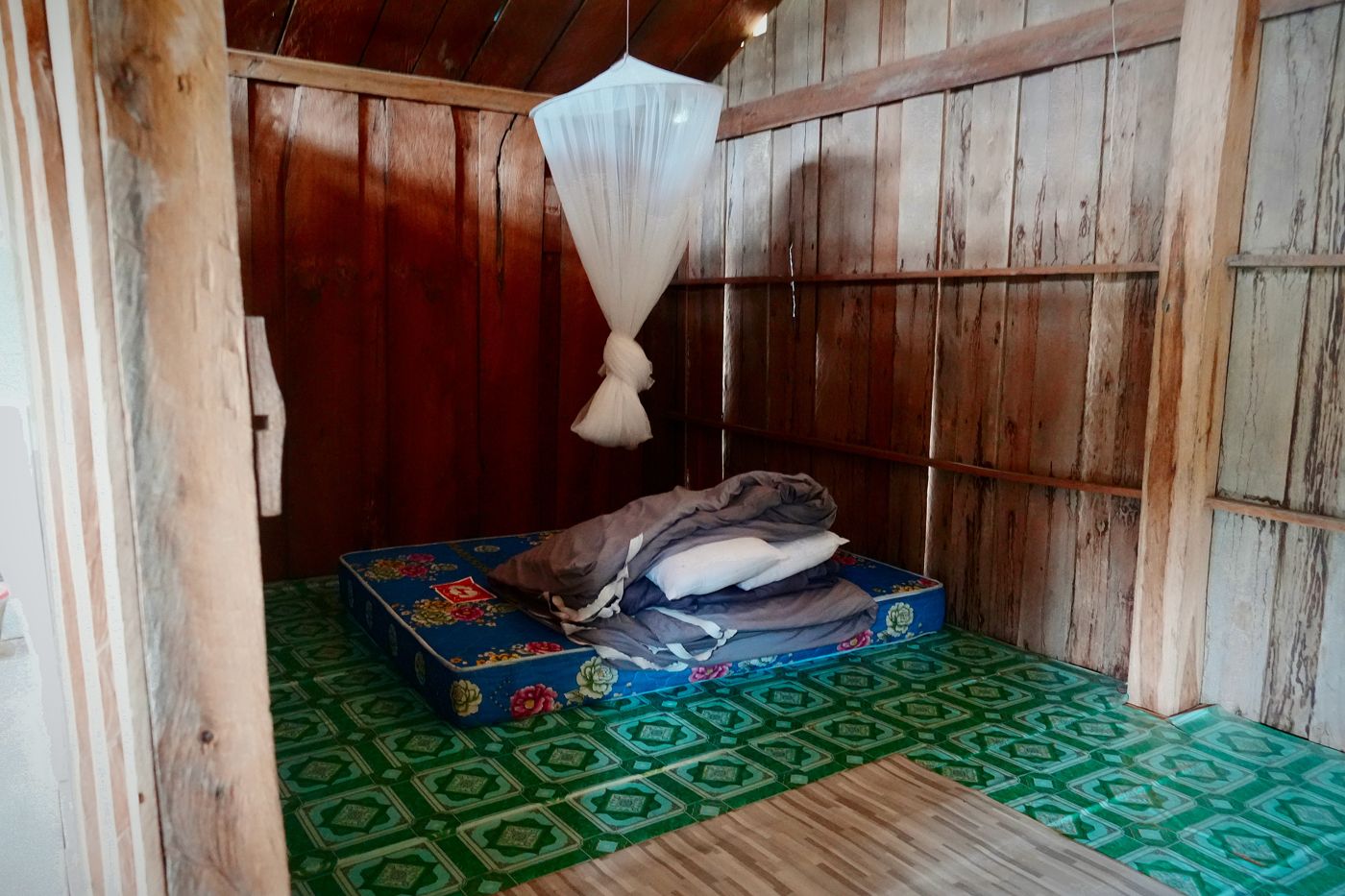 Mattress and mosquito net in a wooden room