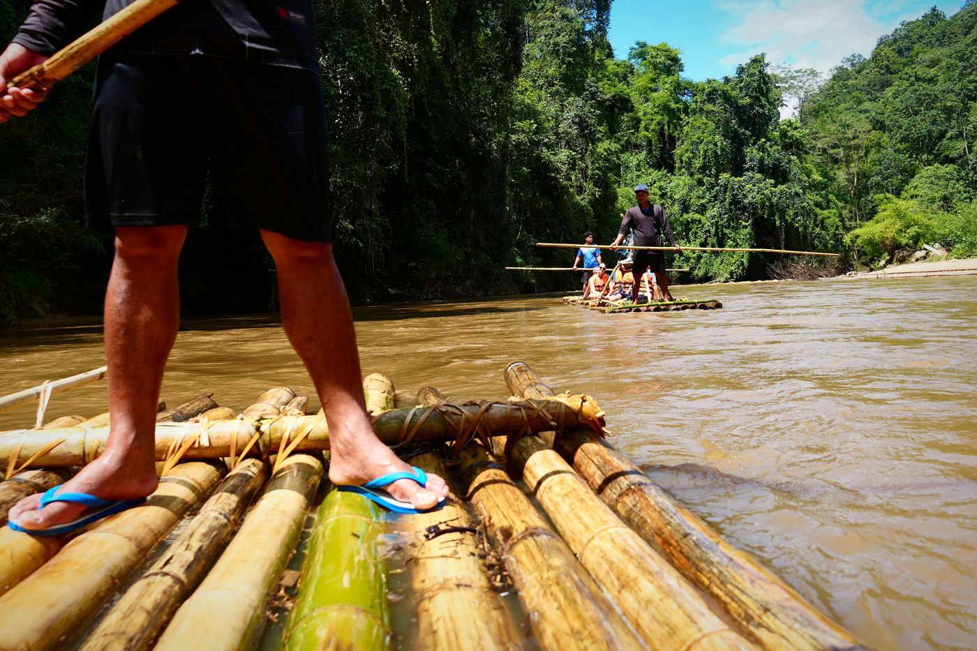 Bare feet on a bamboo raft on the river
